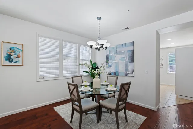 a dining room with furniture a chandelier and wooden floor