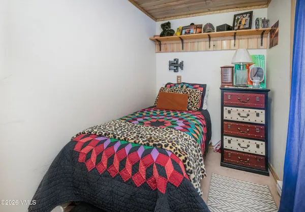 a bedroom with a bed and a book shelf