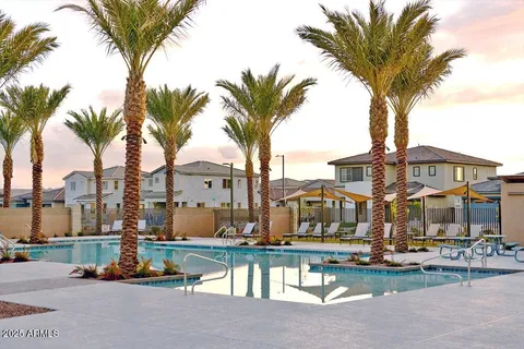 a front view of multi story residential apartment building with yard and outdoor seating