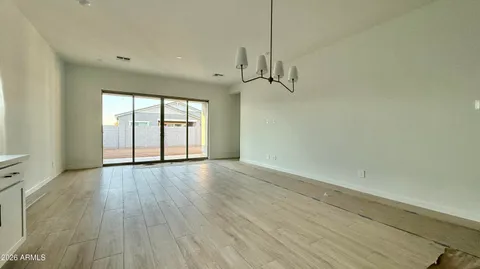 a view of empty room with wooden floor and window