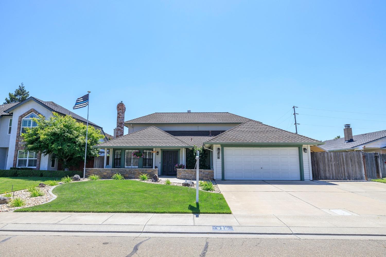 a front view of a house with a garden and plants