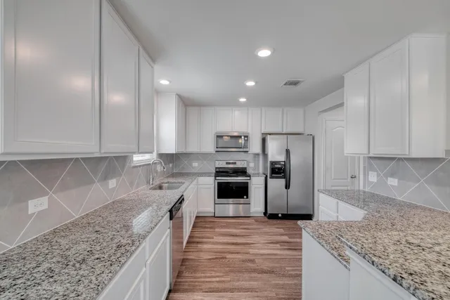 a kitchen with refrigerator cabinets and wooden floor
