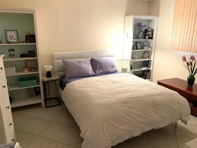 a large bed sitting in a bedroom next to a window