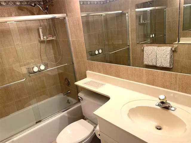 a bathroom with a sink and mirror with bathtub