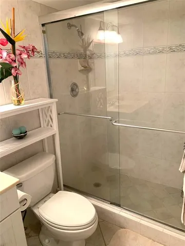 a white toilet sitting next to a shower