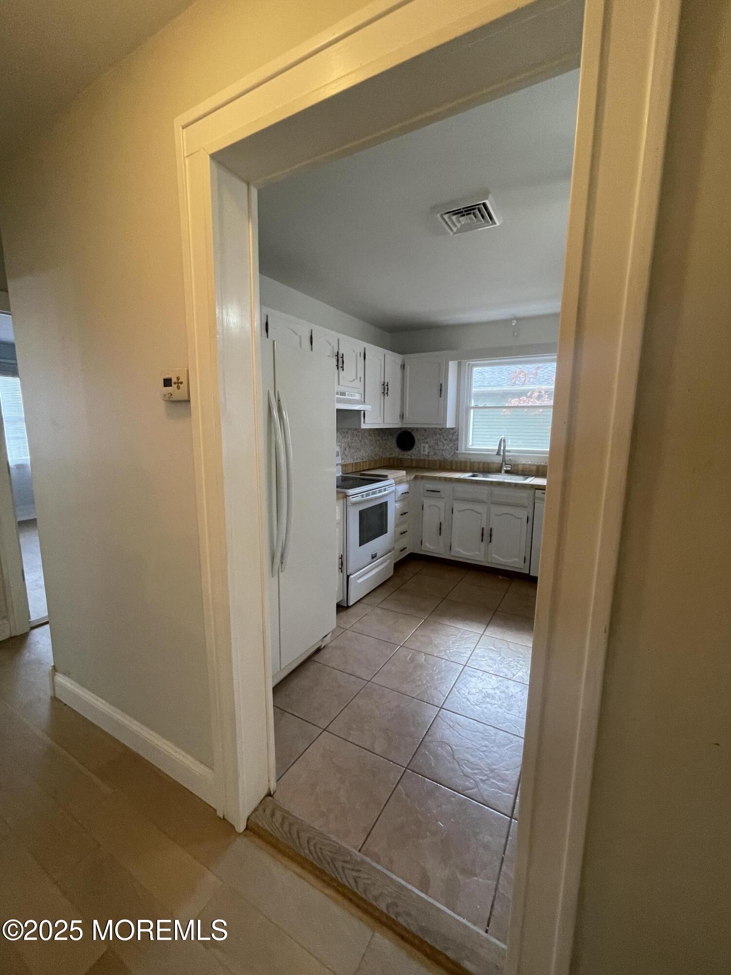 35 Sycamore Access Road, Unit 12 Manahawkin, NJ 08050 - Photo 14 of 34 a kitchen with refrigerator and cabinets