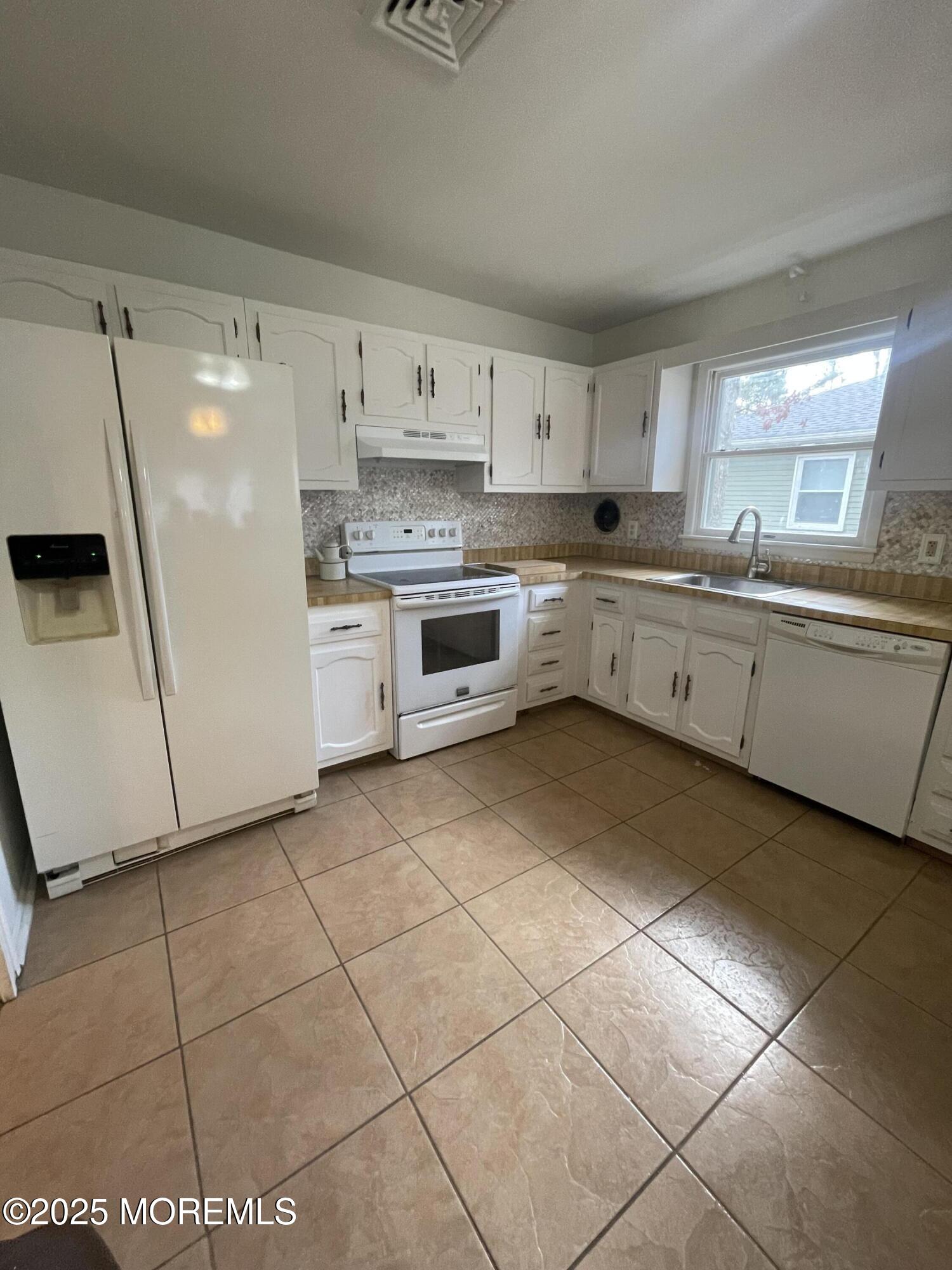 35 Sycamore Access Road, Unit 12 Manahawkin, NJ 08050 - Photo 17 of 34 a kitchen with a stove a sink and a refrigerator