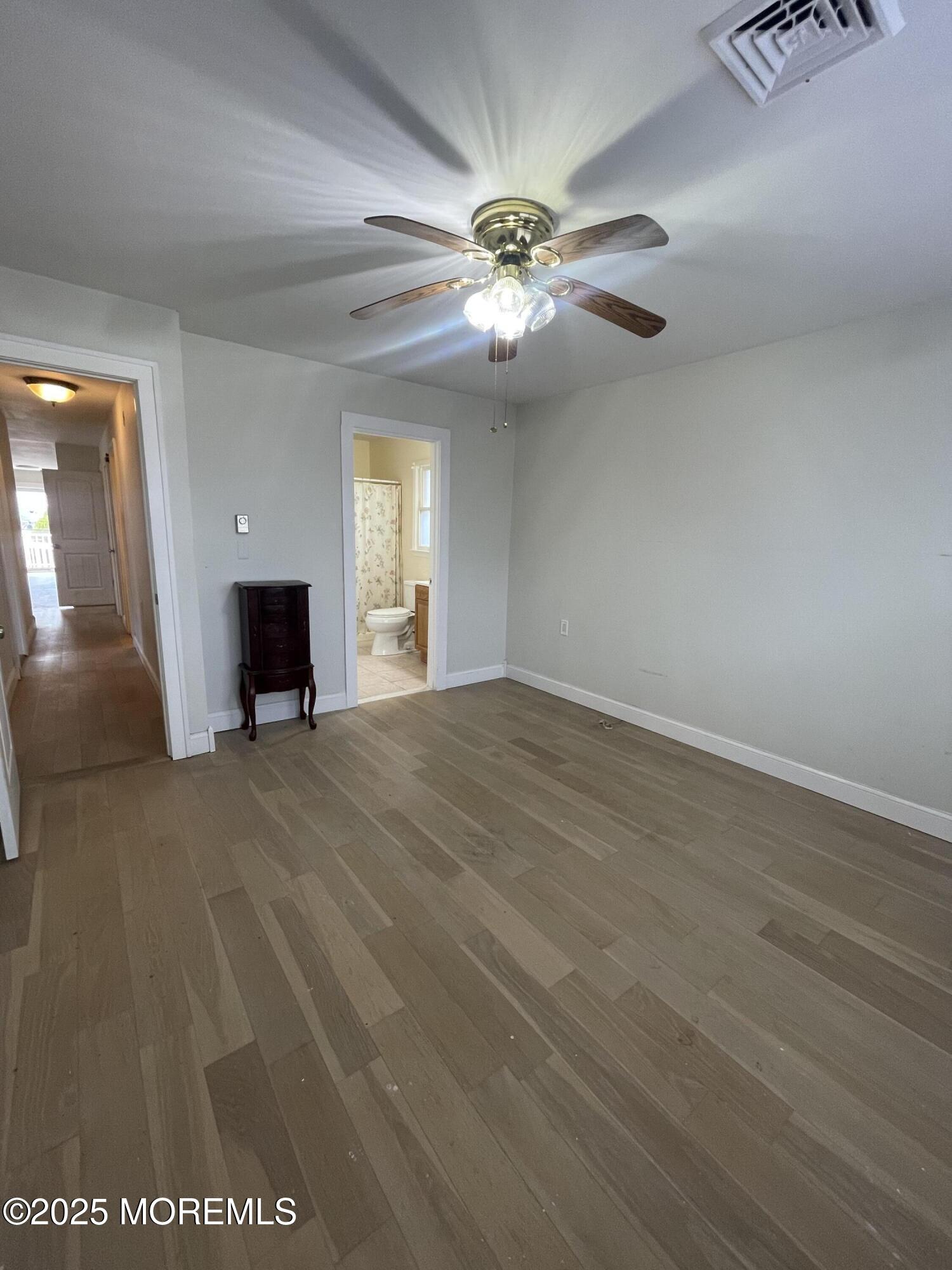 35 Sycamore Access Road, Unit 12 Manahawkin, NJ 08050 - Photo 26 of 34 a view of a livingroom with a fireplace a ceiling fan and wooden floor