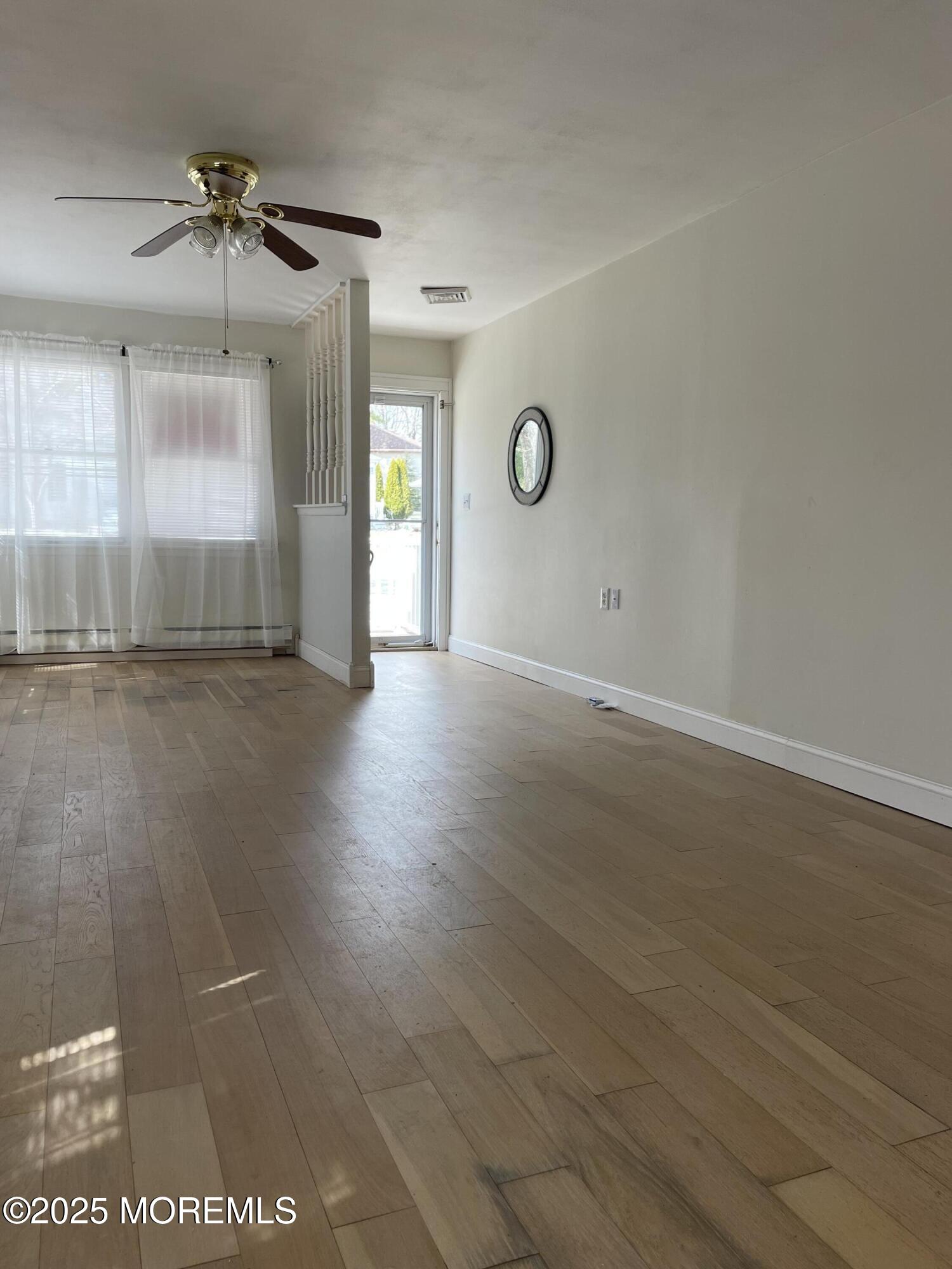 35 Sycamore Access Road, Unit 12 Manahawkin, NJ 08050 - Photo 8 of 34 an empty room with wooden floor and windows