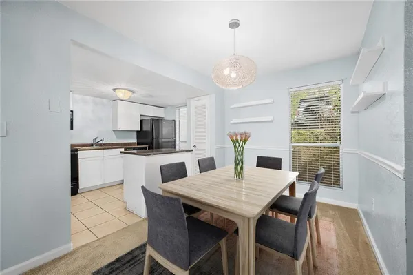 a kitchen with a table chairs a sink and cabinets