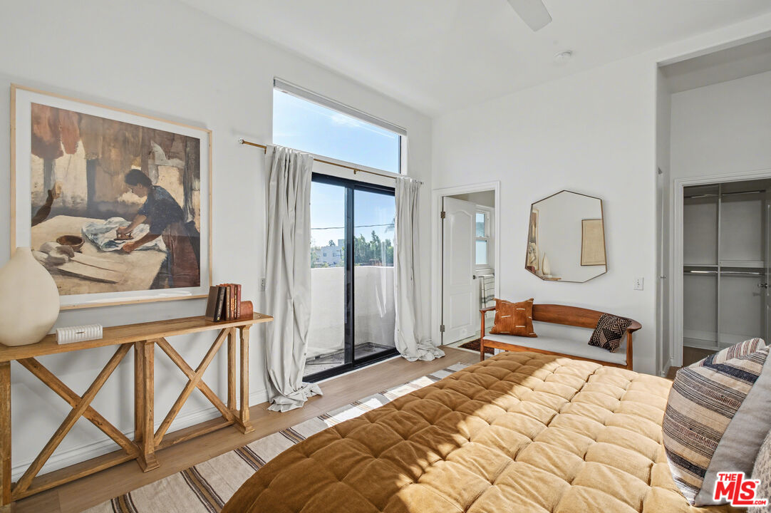 9917 Tabor Street, Unit 2 Los Angeles, CA 90034 - Photo 22 of 38 a bedroom with a bed a table and painting on the wall