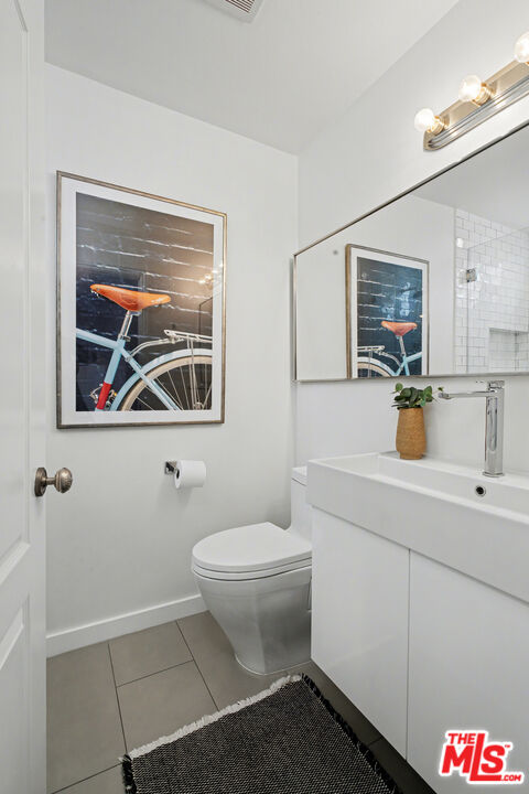 9917 Tabor Street, Unit 2 Los Angeles, CA 90034 - Photo 30 of 38 a bathroom with a toilet a sink and mirror
