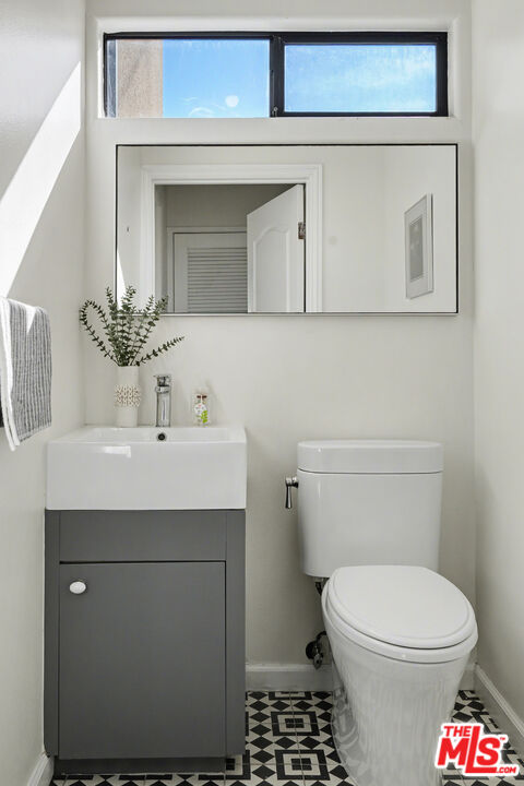 9917 Tabor Street, Unit 2 Los Angeles, CA 90034 - Photo 33 of 38 a bathroom with a sink toilet and mirror