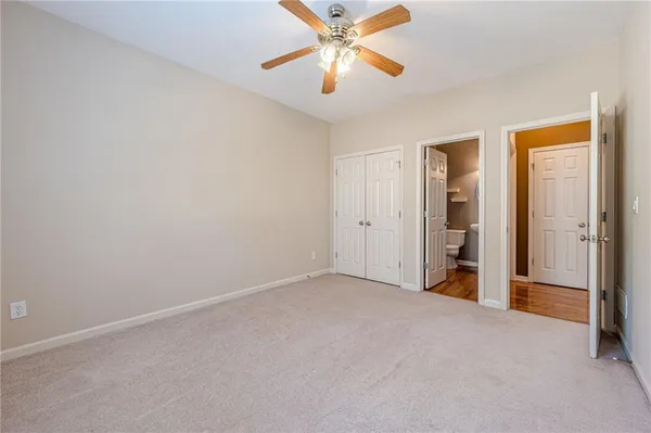 a view of a livingroom with wooden floor a ceiling fan and staircase