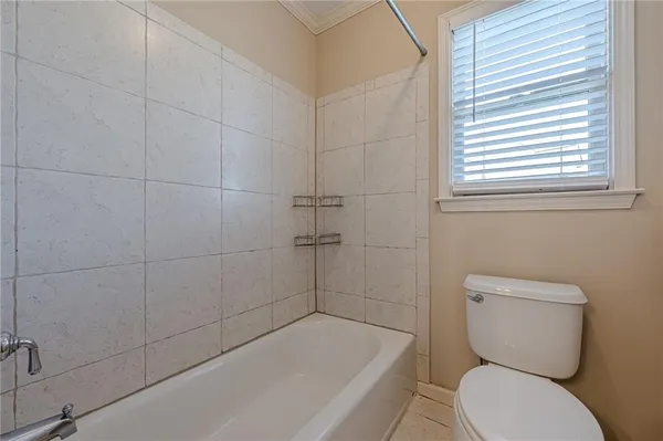 an empty room with a chandelier fan and windows