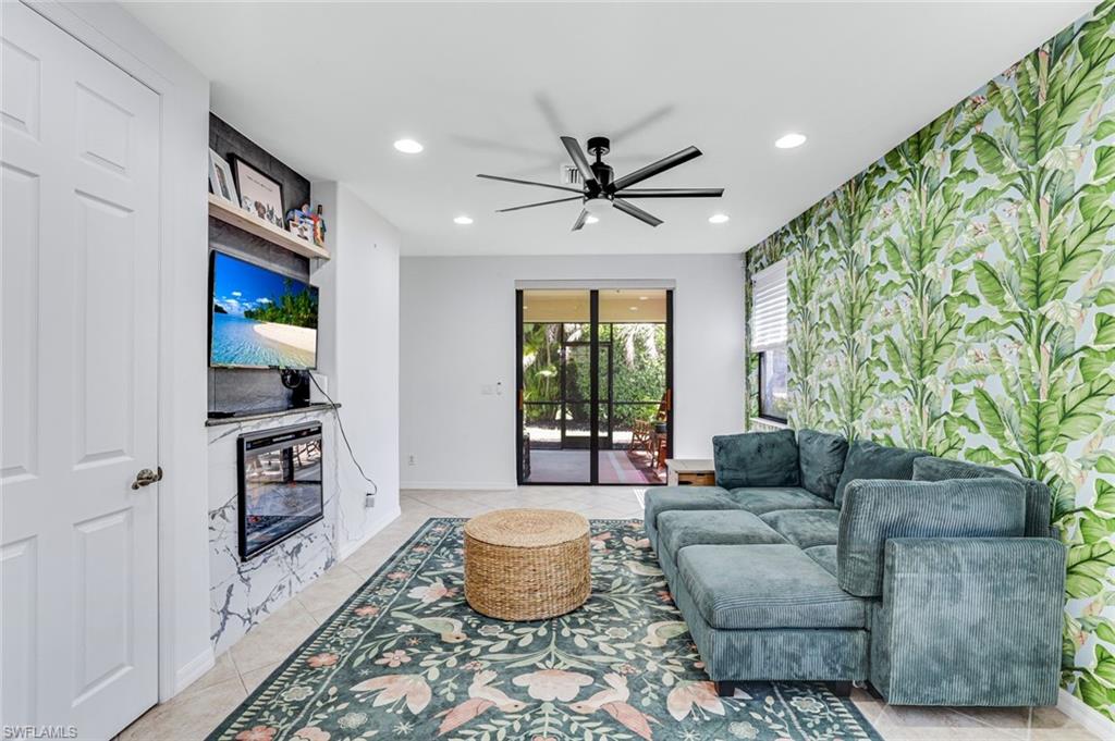 1307 Kendari Terrace Naples, FL 34113 - Photo 13 of 45 Living room featuring a ceiling fan, recessed lighting, wallpapered walls, light tile patterned floors, and an accent wall