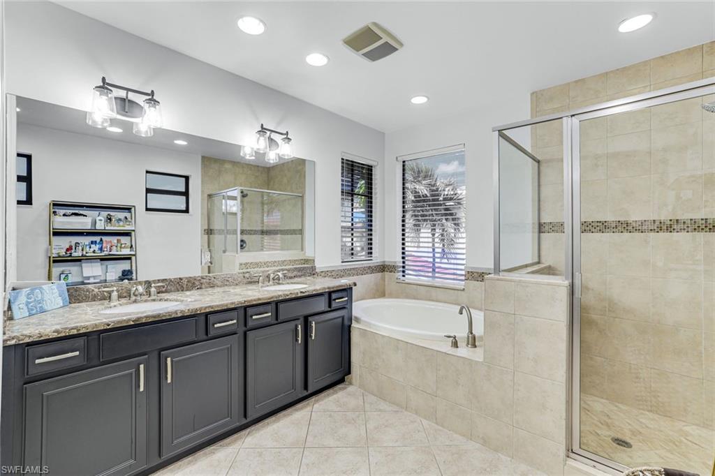 1307 Kendari Terrace Naples, FL 34113 - Photo 22 of 45 Bathroom with double vanity, light tile patterned flooring, a stall shower, a garden tub, and recessed lighting