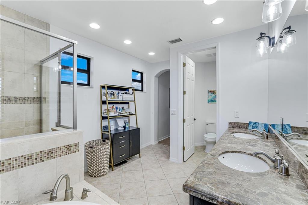 1307 Kendari Terrace Naples, FL 34113 - Photo 23 of 45 Full bath with double vanity, light tile patterned flooring, a shower stall, a bath, and recessed lighting