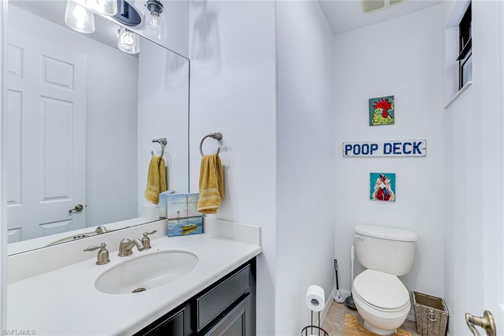 1307 Kendari Terrace Naples, FL 34113 - Photo 27 of 45 Half bath with vanity and toilet