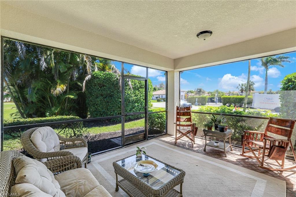 1307 Kendari Terrace Naples, FL 34113 - Photo 28 of 45 Sunroom / solarium featuring a textured ceiling and outdoor seating