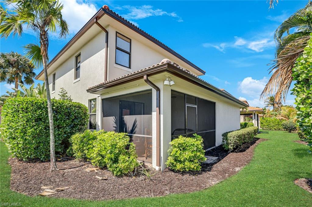 1307 Kendari Terrace Naples, FL 34113 - Photo 31 of 45 View of side of property featuring a tiled roof, a lawn, stucco siding, and a sunroom