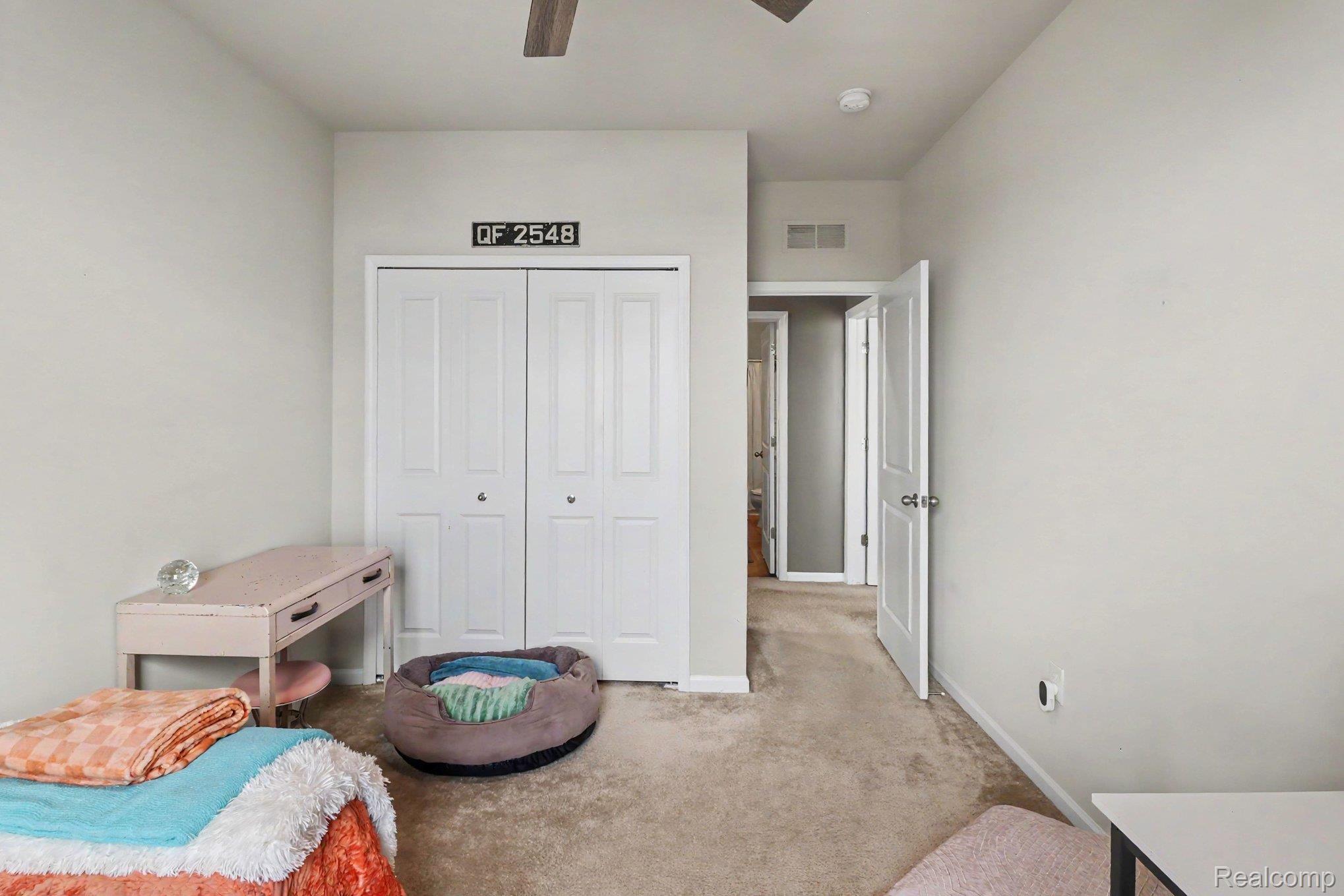 9864 Ridge Run Street Howell, MI 48855 - Photo 20 of 23 Bedroom featuring a closet, carpet floors, and a ceiling fan