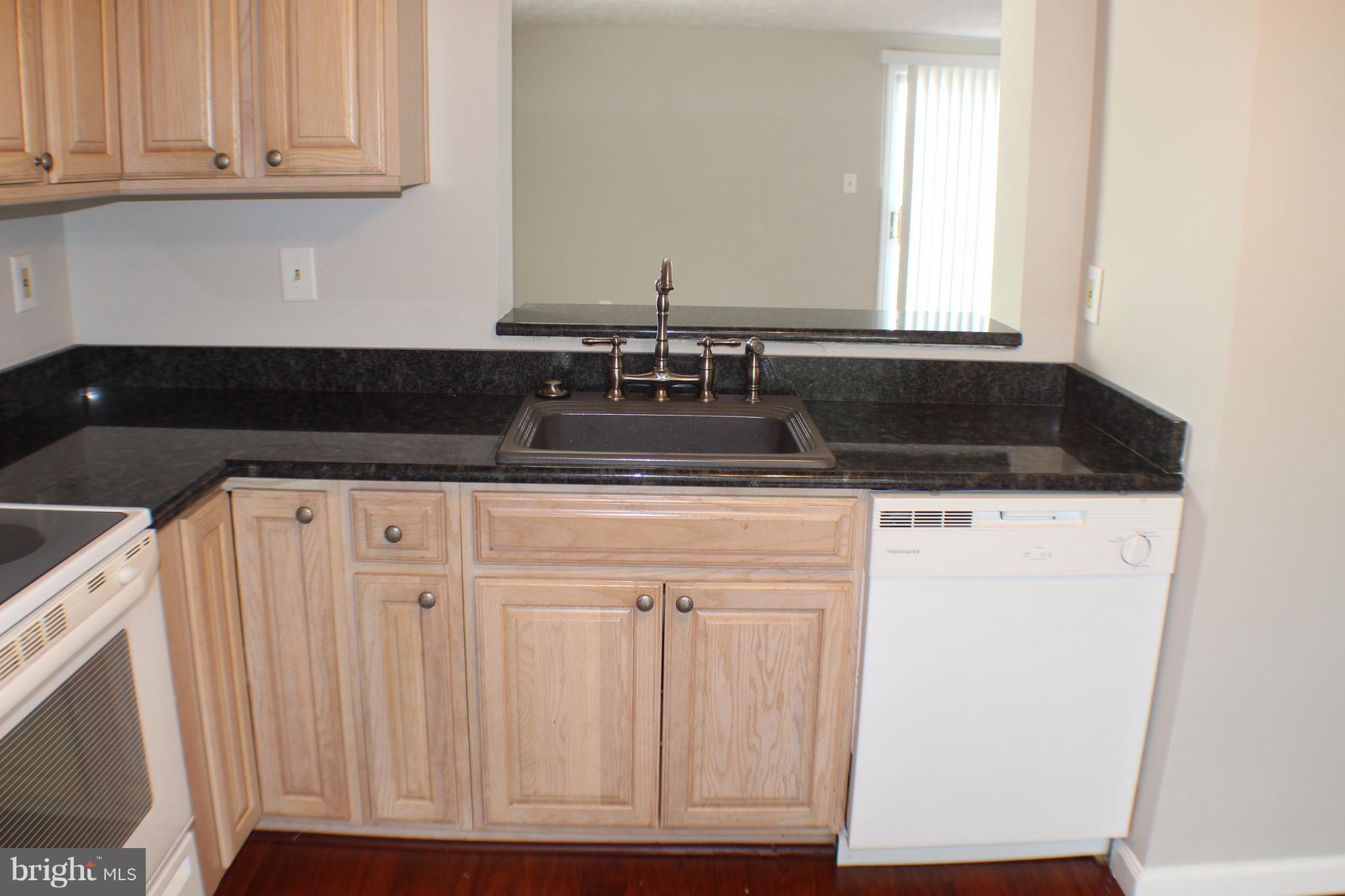 6308 Greenfield Road Elkridge, MD 21075 - Photo 3 of 14 a sink sitting inside of a kitchen with granite countertop white cabinets and a sink