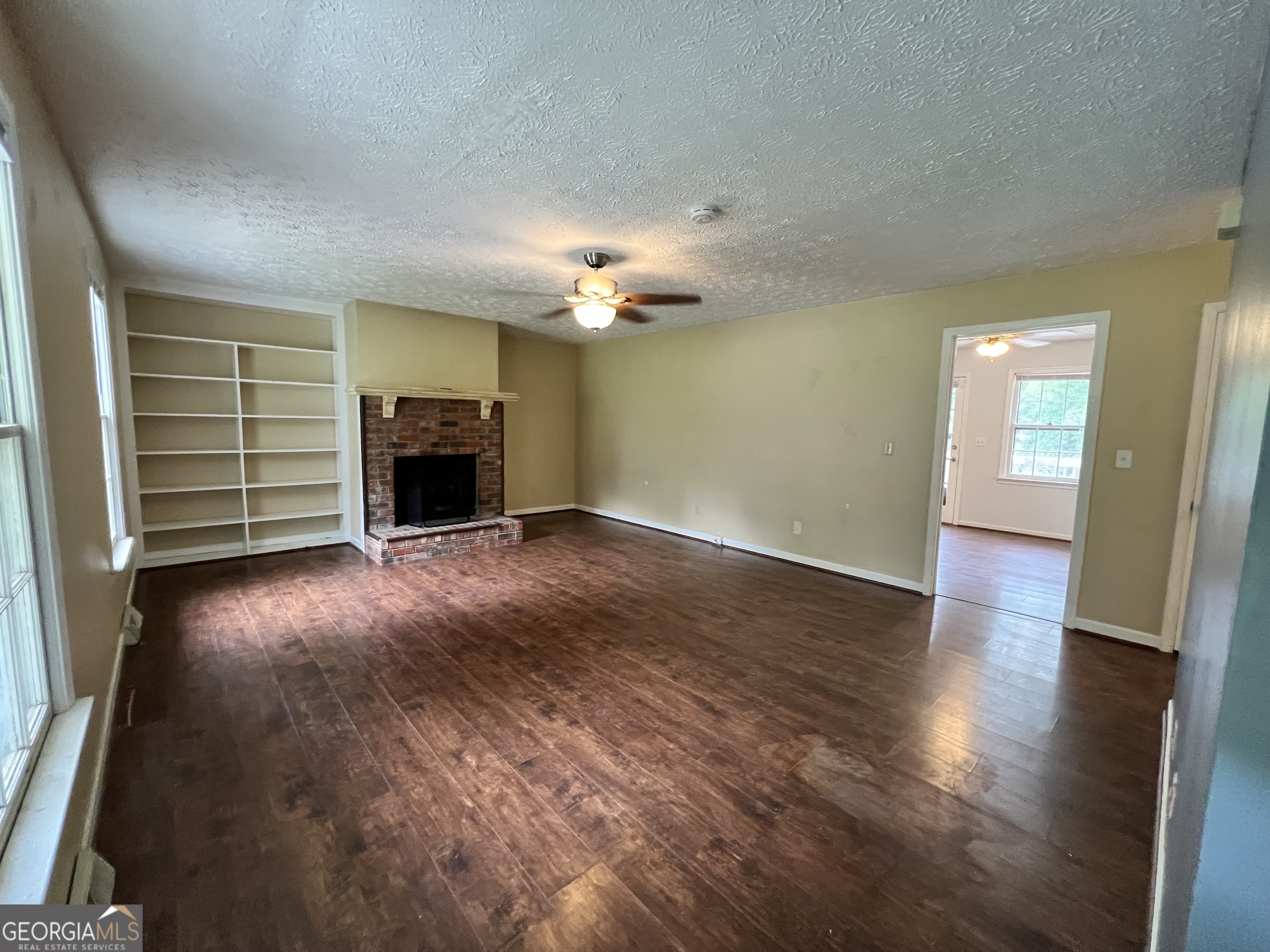 32 Ford Drive Southeast Rome, GA 30161 - Photo 4 of 49 an empty room with wooden floor fireplace and windows