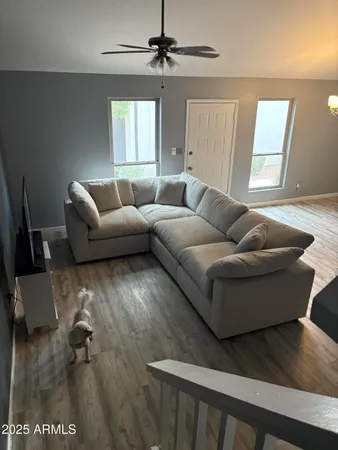 a living room with furniture and a wooden floor