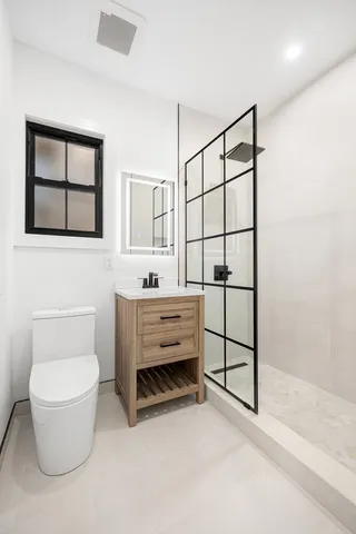 a bathroom with a toilet sink and mirror