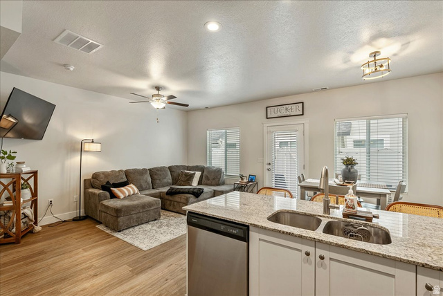 287 North 100th West Morgan, UT 84050 - Photo 27 of 27 Kitchen with open floor plan, dishwasher, white cabinets, light stone countertops, and a textured ceiling