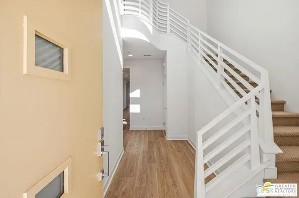 a view of a hallway with wooden floor and staircase