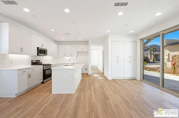 a kitchen with a white wooden cabinets and white appliances