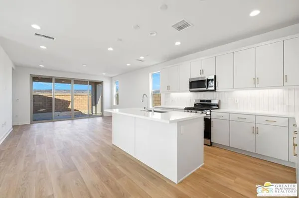a kitchen with stove a sink and a refrigerator