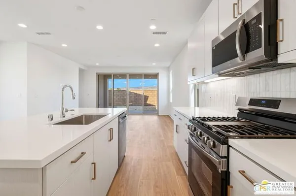 a kitchen with stainless steel appliances a sink stove and cabinets