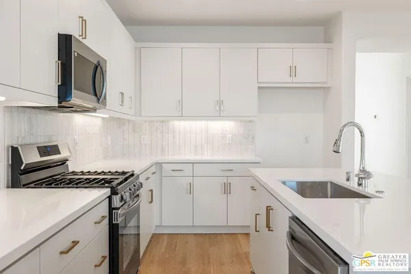 a kitchen with granite countertop a sink a stove and cabinets