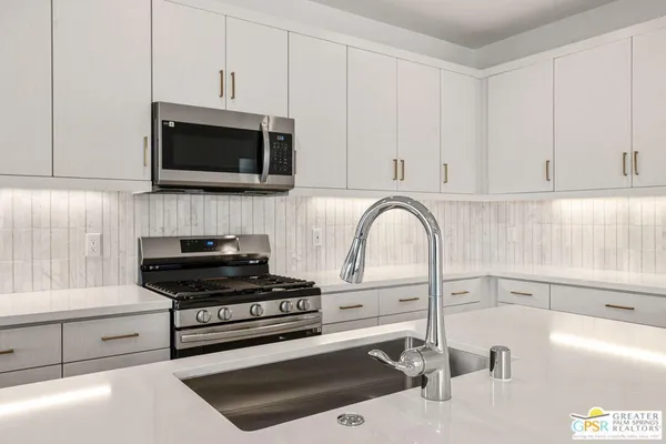 a kitchen with a sink a stove and cabinets