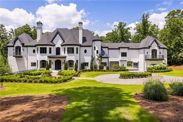 a view of a house with a big yard and potted plants