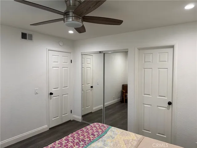 a bedroom with a walk in closet and wooden floor