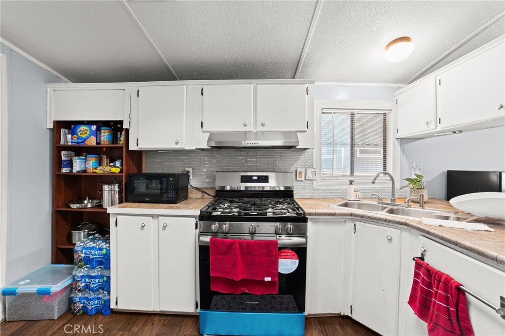 1155 South Riverside Avenue, Unit 22 Rialto, CA 92376 - Photo 15 of 34 a kitchen with a stove a sink and a refrigerator
