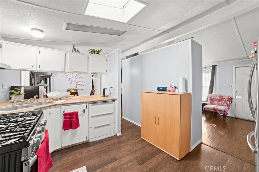 1155 South Riverside Avenue, Unit 22 Rialto, CA 92376 - Photo 16 of 34 a kitchen with kitchen island granite countertop a sink and refrigerator