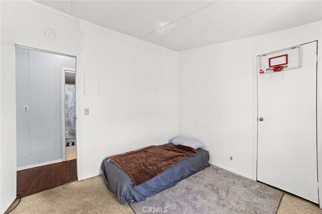 1155 South Riverside Avenue, Unit 22 Rialto, CA 92376 - Photo 24 of 34 a living room with a bed and a walk in closet