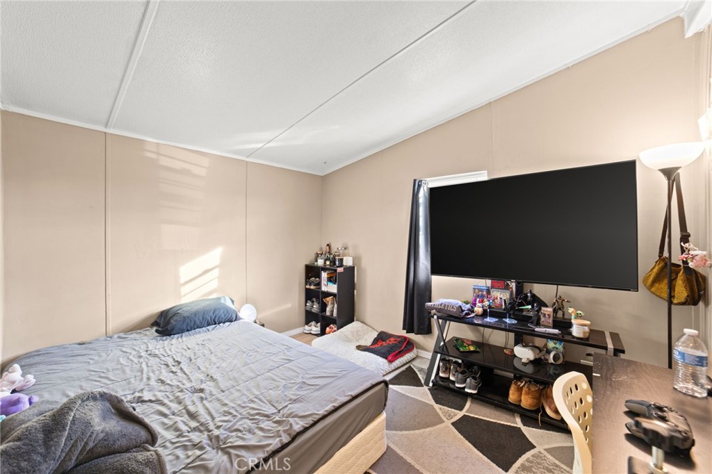 1155 South Riverside Avenue, Unit 22 Rialto, CA 92376 - Photo 26 of 34 a bedroom with a bed and a flat screen tv