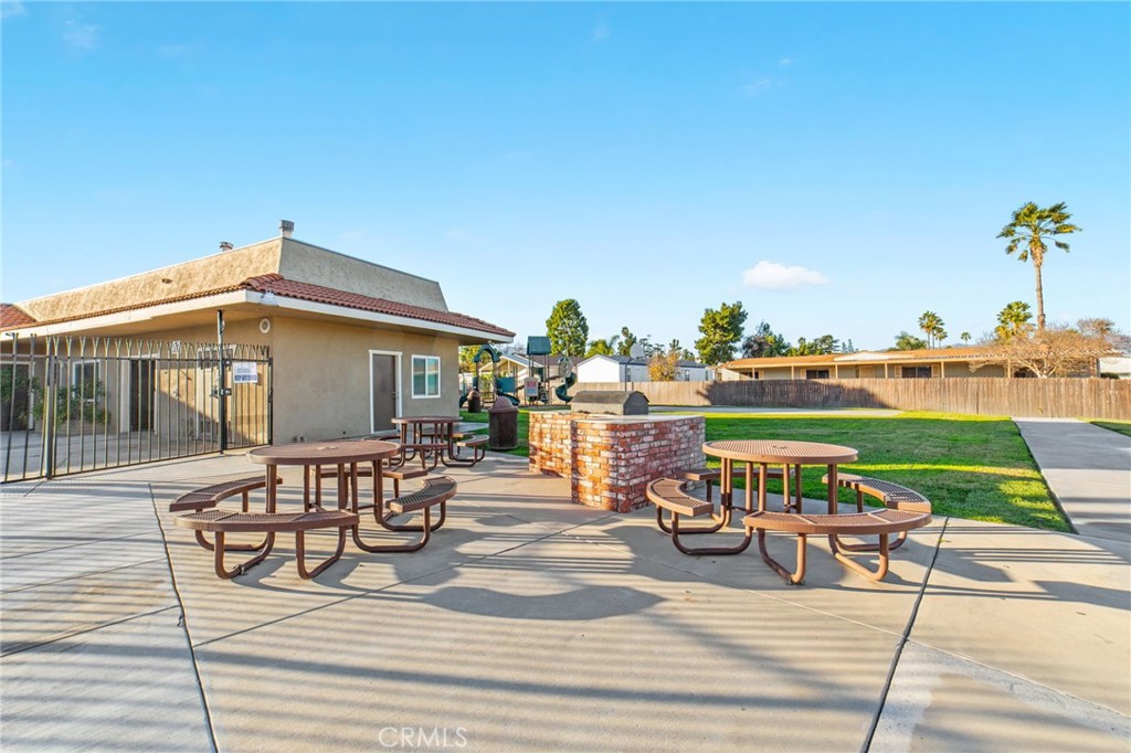 1155 South Riverside Avenue, Unit 22 Rialto, CA 92376 - Photo 31 of 34 a view of a patio with table and chairs potted plants with wooden floor and fence
