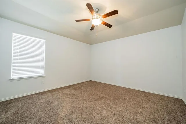 an empty room with closet and windows