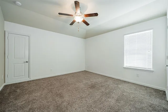 an empty room with closet and a chandelier fan