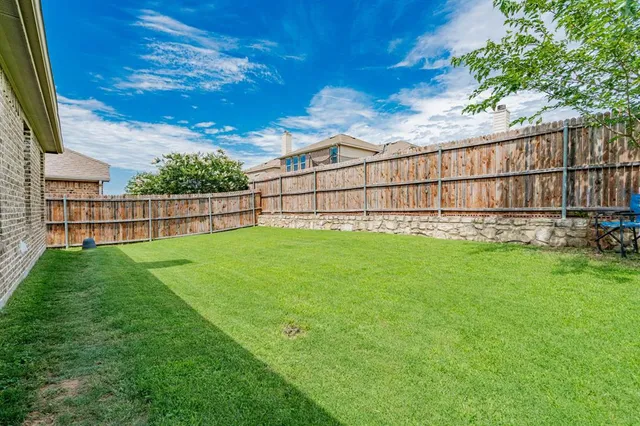 a view of a backyard with a wooden fence