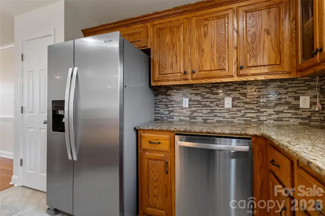 a large kitchen with kitchen island granite countertop wooden cabinets a granite counter tops and a large window