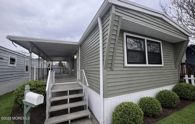 a view of a house with wooden door and a yard