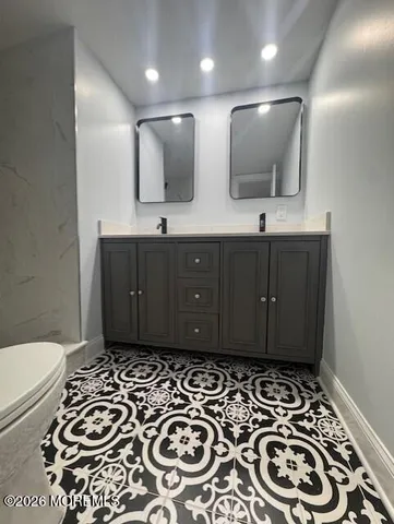 a bathroom with a sink a toilet and mirror